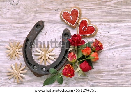 Horseshoes, straw  stars, hearts, with roses on wooden background 