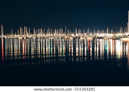 Yachts and boats in marina of La Spezia at night with reflection in water. Italy