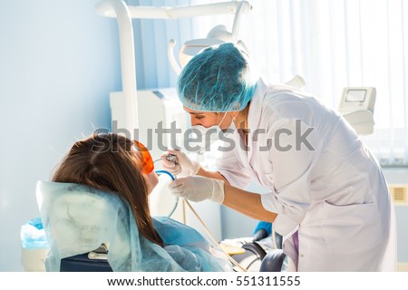 woman dentist at work with patient Royalty-Free Stock Photo #551311555
