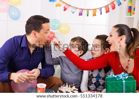 Family in living room with birthday cake.