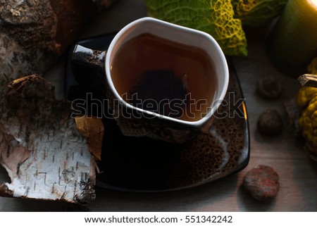 Cup of tea on autumn background with vegetables