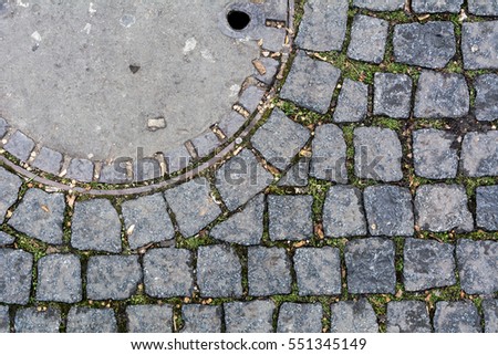 Pavement top view. Pavement texture. Background of old cobblestone pavement close-up. Pavement road stone. Texture of the modern street architecture. View from above. Round Manhole Cover Utility Shaft