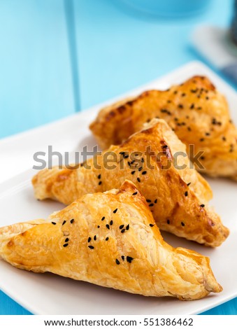 Homemade cheese puff pastries on blue wooden background Royalty-Free Stock Photo #551386462