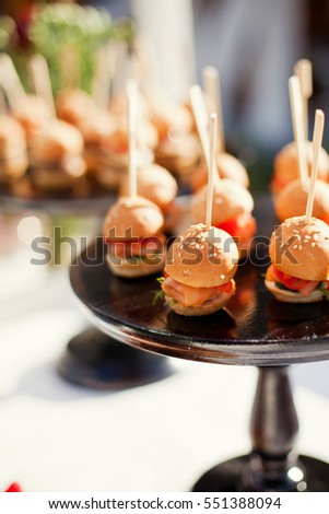 Small burgers served on one plate as appetizers