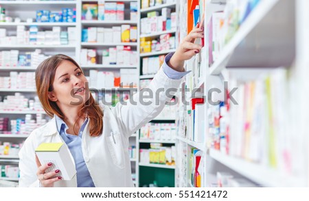 Photo of a professional pharmacist checking stock in an aisle of a local drugstore.