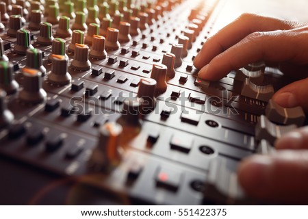 Sound recording studio mixing desk with engineer or music producer Royalty-Free Stock Photo #551422375