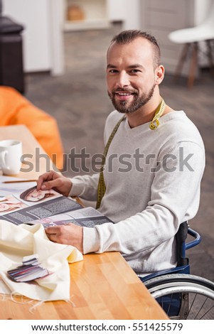 Enthusiastic handicapped dressmaker reading fashion magazines