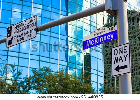McKinney street sign in downtown Houston, Texas with a modern skyscraper in the background.