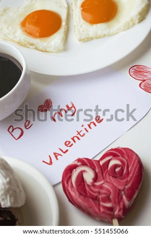 Breakfast on Valentine's Day-fried eggs in the shape of a heart,coffee and a piece of cake.pink rose.with word be my Valentine.Happy lovers day.Valentine's day holiday.Valentine's day concept