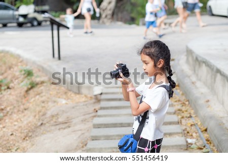 Young girl taking a camera