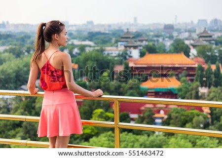 China summer travel. Woman tourist relaxing looking at view of famous chinese landmark, the Forbidden City in Beijing. Jingshan Gongyuan park.