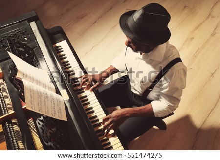 Afro American man playing piano Royalty-Free Stock Photo #551474275