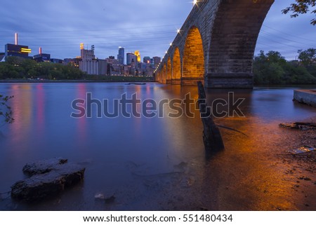 Wide Angle Shot of the Minneapolis Skyline, Mississippi River, and Iconic Stone Arch Bridge during Blue Hour
