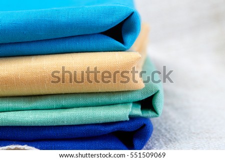 Home interior, tailor, sewing, diy concept. Heap of colorful cloth fabrics. Color Wool, cotton linen clothes. Closeup. White background Royalty-Free Stock Photo #551509069