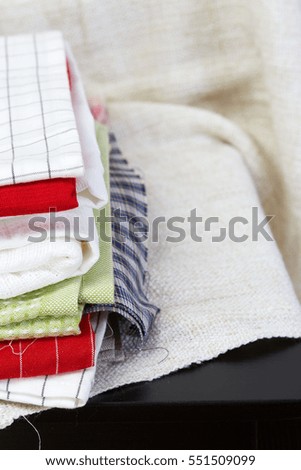 Home interior, tailor, sewing, diy concept. Heap of colorful cloth fabrics on wooden chair. Color Wool, cotton linen clothes. Closeup.  White background