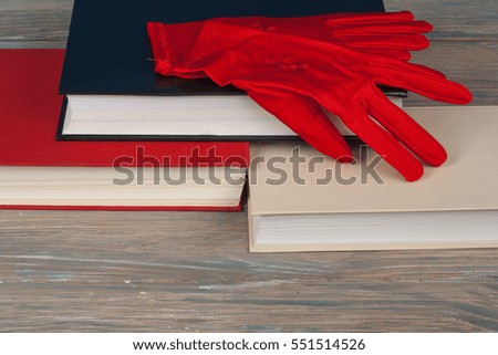 Book stacking. Open book, hardback books on wooden table and blue background. Back to school. Copy space for text. Knitted gloves.