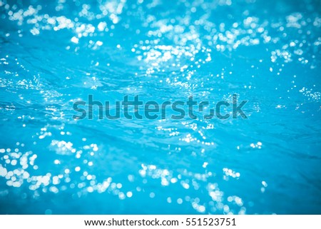 Water and air bubbles over blue background,sea wave ,Bokeh light background in the pool,Hotel swimming pool with sunny reflections.