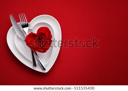 Red rose on white dish.Meal on Valentines Day Royalty-Free Stock Photo #551535430