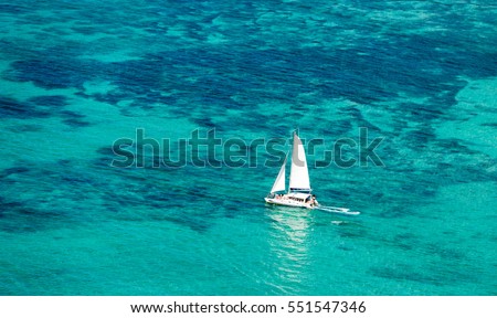 Aerial picture of Mauritius Island lagoon. Aerial view of Catamaran boat sailing in turquoise lagoon.