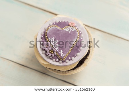 Cupcake with heart on a wooden table