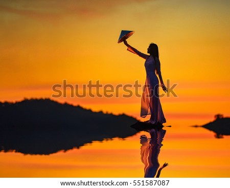 Beautiful  woman with Vietnam culture traditional dress on during sunset,Vietnam Royalty-Free Stock Photo #551587087