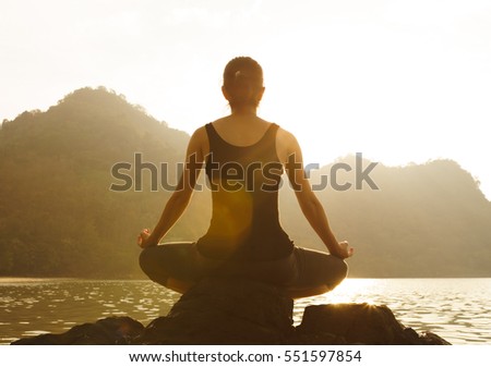 Silhouette yoga meditation girl on the background of the sea and sunset, Healthy lifestyle. 