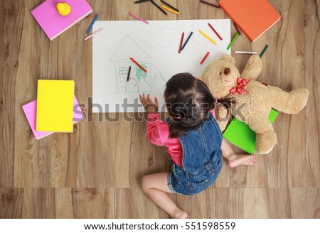Top view of little girl drawing in paper and sitting at home, Baby healthy and preschool concept