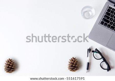 White office desk table with laptop,pinecone and glass. Top view with copy space, flat lay.