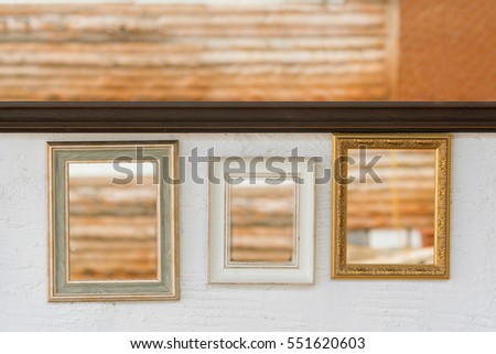Mirrors in gold, silver and  white frames on a white wall