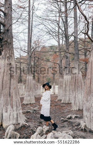 pregnant woman in park on a background of trees