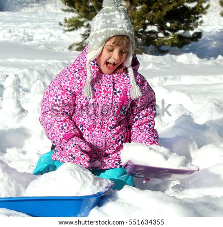 Happy snowy holidays. Picture of a little girl playing with snow in a mountain forest