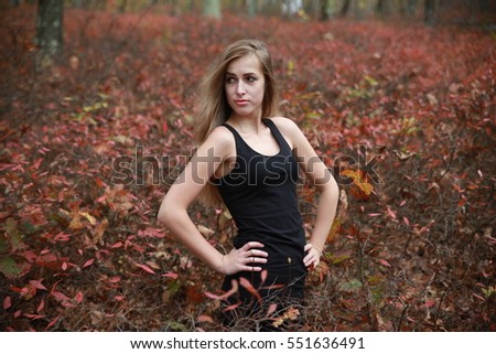 Beautiful blonde woman feeling freedom and enjoying nature fresh air with hands near her mouth while sitting at autumn or spring forest outdoors wearing black short dress,  portrait a beautiful bokeh
