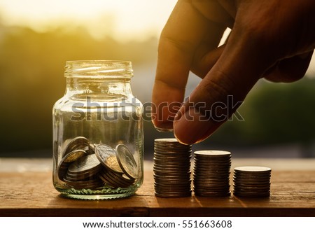 Hand with rows of coins and account for finance and banking concept, Hand with money coin stack growing business, Saving money concept, Save money for retirement planing Royalty-Free Stock Photo #551663608
