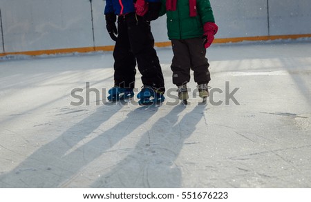 little girl and boy larning to skate in winter