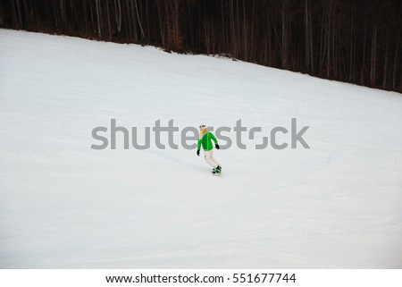 Back view picture of young man snowboarder on the slopes frosty winter day.
