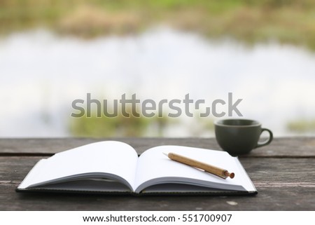 Pencil on open notebook , Shallow depth , Pencil and nature bokeh background