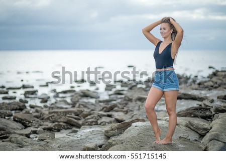  Shallow Depth of Field image of a Pretty girl Posing on a Rocky beach, at Gatakers Bay,Queensland, Australia