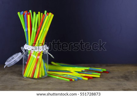 colored plastic cocktail tubes standing in a glass side view