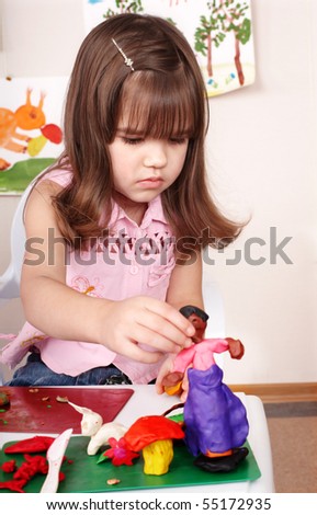 Little girl  moulding of plasticine .	