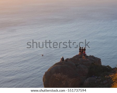 Group of Hikers see view sunset from the rock on the way to on top of Lion's Head mountain with the sea background  in Cape Town, South Africa, Table Mountain national park