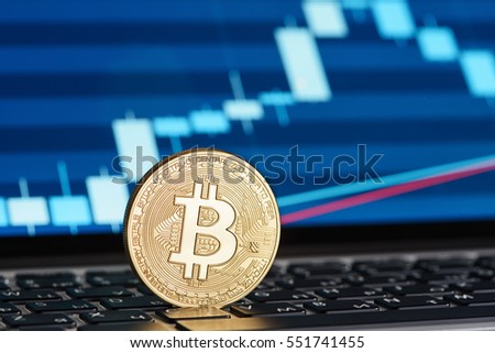 Golden Bitcoin coin on the laptop keyboard