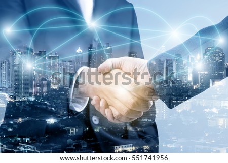 Double exposure of handshake with blur city night and network connection concept  Royalty-Free Stock Photo #551741956