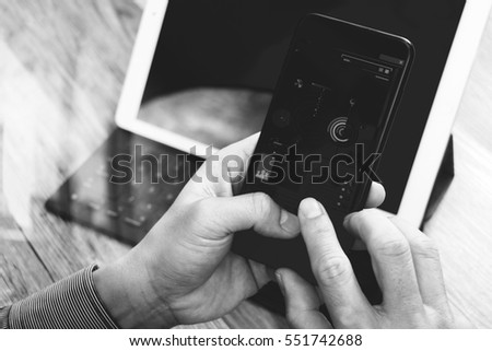 close up of hand using mobile payments online shopping,omni channel,in modern office wooden desk,icons graphic interface screen,eyeglass,filter,black white