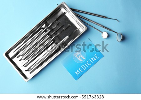 Business card and dental tools on blue background. Medical service concept