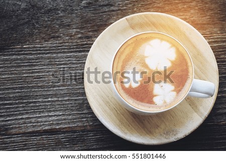 Vintage hot coffee cup with nice Latte art decoration on old wooden texture table