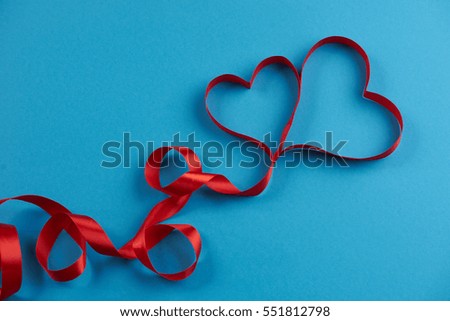 Ribbons shaped as hearts on blue background, In love card concept. Valentine's day theme
