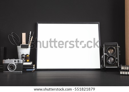 Mock up photo frame with camera. White blank frame and medium format camera on photographer table.