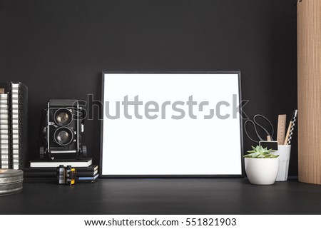 Mock up photo frame with camera. White blank frame and medium format camera on photographer table.