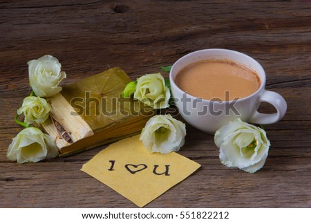 Coffee cup with spring flower lisianthus and notes I love you on wooden table