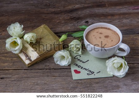 Coffee cup with spring flower lisianthus and notes good morning on wooden table